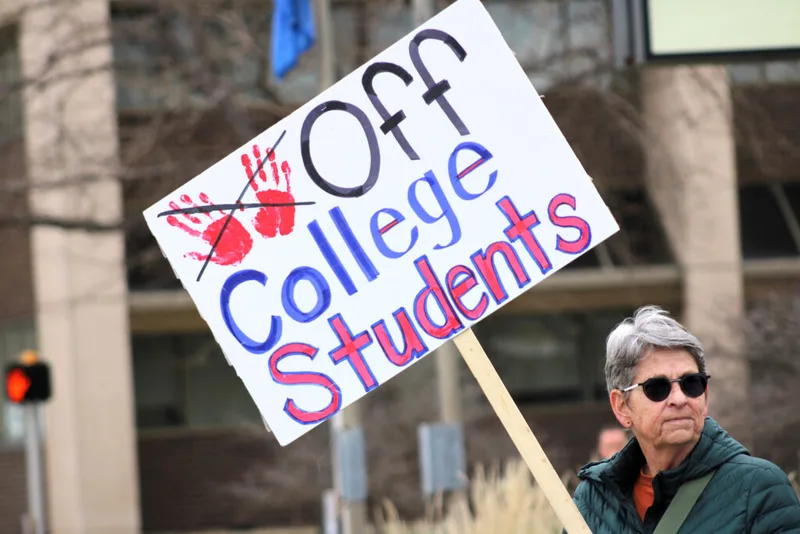 Protestor Pat Braun carries a sign April 23, 2025, in Rapid City, South Dakota, to protest the cancellation of student visas. (Photo by Seth Tupper/South Dakota Searchlight)