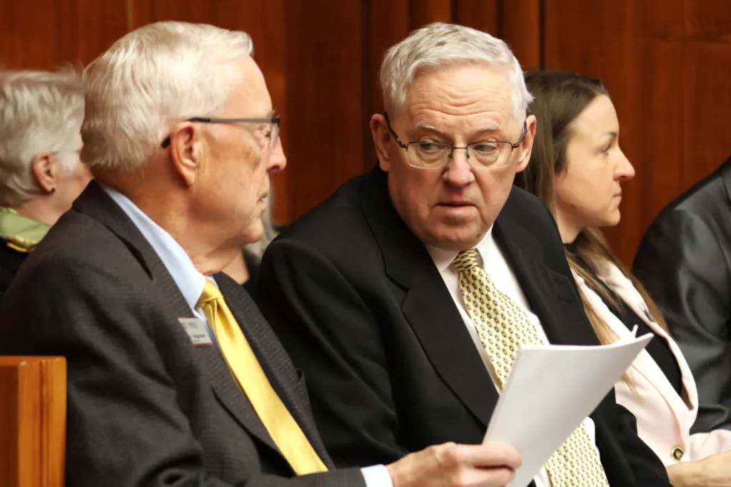 Commissioners Murray Sagsveen, left, and Ronald Goodman, right, members of the North Dakota Ethics Commission, listen to a House committee hearing on March 18, 2025. (Michael Achterling/North Dakota Monitor)